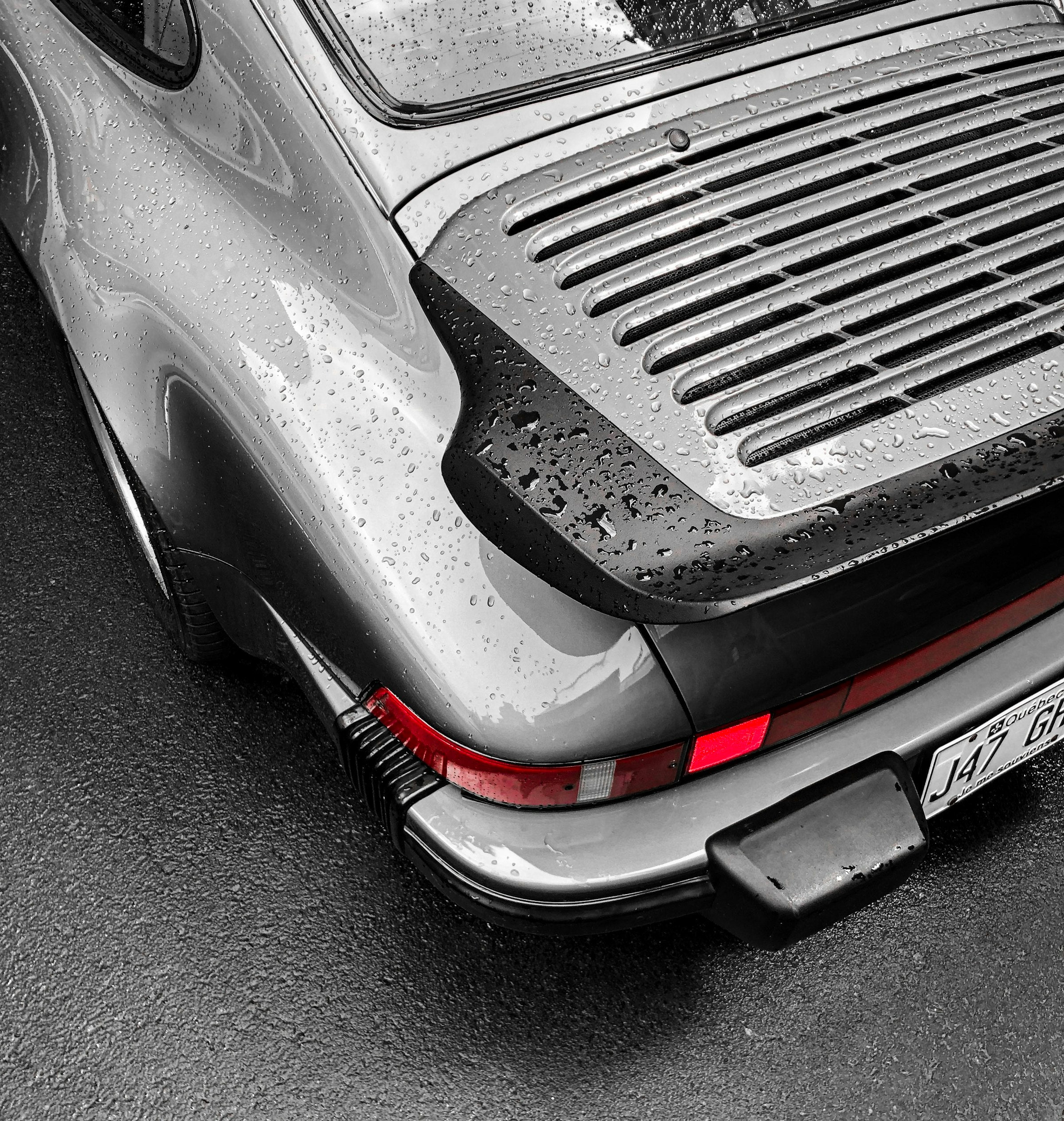 Rain beading on the rear engine grille of a silver classic 911